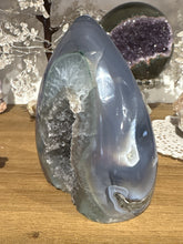 Load image into Gallery viewer, Detail view of polished Brazilian agate flame displaying dark grey druzy pockets and impressive size