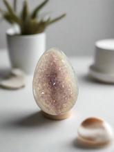 Load image into Gallery viewer, Close-up of agate geode egg displaying natural crystal formations and unique banding patterns