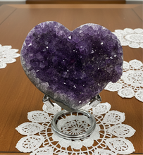 Load image into Gallery viewer, Heart-shaped Uruguayan amethyst crystal specimen with deep purple crystallization displayed on silver stand