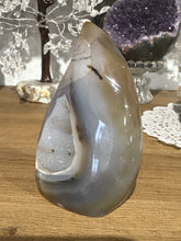 Load image into Gallery viewer, Detail view of polished Brazilian agate flame displaying crystal formations within natural vug and grey banding