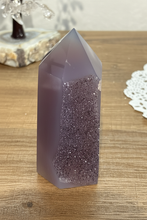 Load image into Gallery viewer, Polished purple-grey agate tower with horizontal druzy crystal band displayed upright on light wood surface