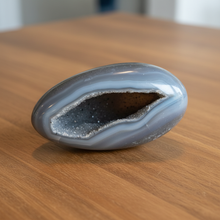 Load image into Gallery viewer, Brazilian agate geode egg with grey-blue banding and druzy crystals with black specks