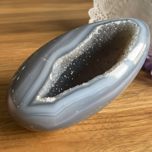 Load image into Gallery viewer, Brazilian agate geode egg showing natural banding patterns and polished exterior with crystal cavity
