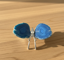 Load image into Gallery viewer, Side view of Brazilian agate butterfly with bright blue banding and natural agate edges, highlighting the silver metal body and polished finish