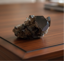 Load image into Gallery viewer, Smokey quartz crystal cluster from Brazil showing massive tabular crystals and dramatic formation on dark wood coffee table, 10x9x5cm premium specimen
