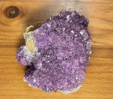 Purple crystal rock on a wooden surface