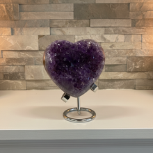 Load image into Gallery viewer, Heart-shaped Uruguay amethyst crystal with deep purple color and polished edges on metal display stand
