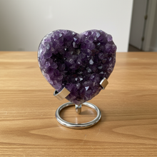 Load image into Gallery viewer, Purple amethyst heart specimen on metal display stand showing crystal formation and natural variations
