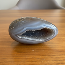 Load image into Gallery viewer, Close-up view of sparkling druzy crystals with black inclusions inside polished agate geode egg from Brazil
