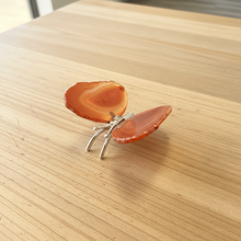 Load image into Gallery viewer, Side view of Brazilian agate butterfly with warm peachy coral tones and natural orange banding, highlighting the silver metal body and polished finish
