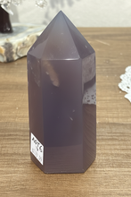 Load image into Gallery viewer, Back view of polished purple-grey agate point highlighting natural mineral inclusion and smooth polished finish
