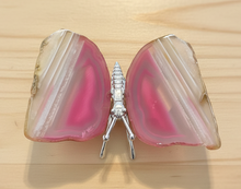 Load image into Gallery viewer, Brazilian agate butterfly specimen with vibrant pink and cream banded wings displayed on wood table, front view showing natural stone patterns
