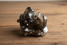 Load image into Gallery viewer, Thunder Bay smokey quartz crystal cluster from Brazil showing dramatic tower formation with multiple termination points on mid-tone wood table, 11x7x5cm specimen
